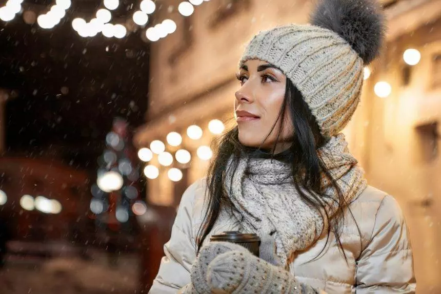 Model in winter clothing with coffee cup posing