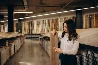 Woman choosing laminate floor for home renovation. In love with natural materials