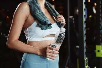 Woman drinking water recovery health exercise workout in gym fitness breaking relax